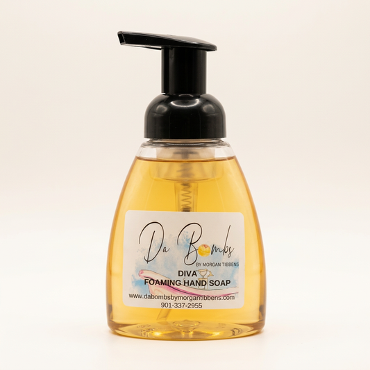 DaBombs Diva foaming hand soap in a clear bottle with a black pump on a warm-white background.